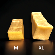A photo of medium and xl yak chew next to each other on a black background, showing that the medium Yak chew is half of the thickness of the XL yak chew